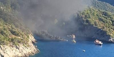 Fethiye'de bir koyda teknede çıkan yangına müdahale ediliyor